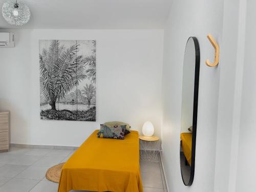 a dining room with a yellow table and a picture on the wall at Promo ! La Villa Armony, Havre de Paix avec Jardin Privé ! in Lamentin