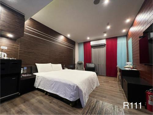 a bedroom with a white bed and a red wall at Catwalk Motel -Tainan in Tainan