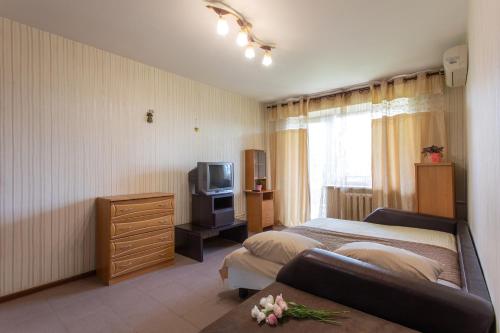 een hotelkamer met 2 bedden en een televisie bij Apartment on 23 Serpnya in Charkov