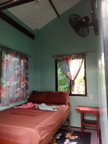 a bedroom with a bed and two windows at Weeroona Huts Homestay Pacifico in San Isidro