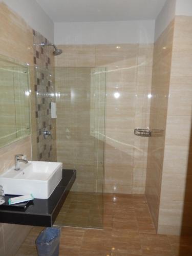 W łazience znajduje się umywalka i prysznic. w obiekcie Grand Amira Hotel w mieście Surakarta