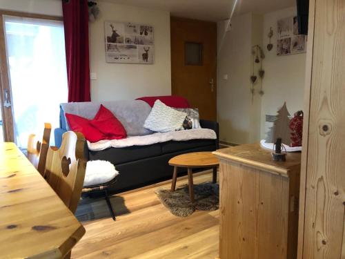 un salon avec un canapé et une table dans l'établissement Charmant T2 proches centre village, aux Rousses