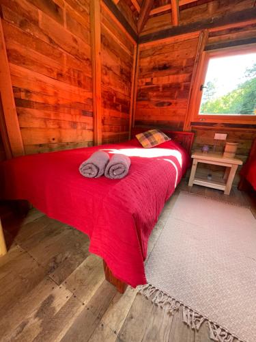 a bedroom with a red bed in a wooden cabin at Brvnare na jezeru Marinkovići in Bajina Bašta