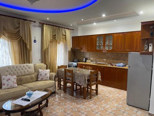 un soggiorno con divano e tavolo e una cucina di Vila Elite a Ksamil