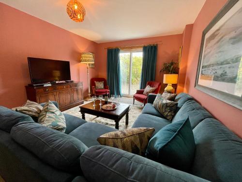 a living room with a blue couch and a tv at Peaceful Sea View Home only 5 miles from Inverness in North Kessock