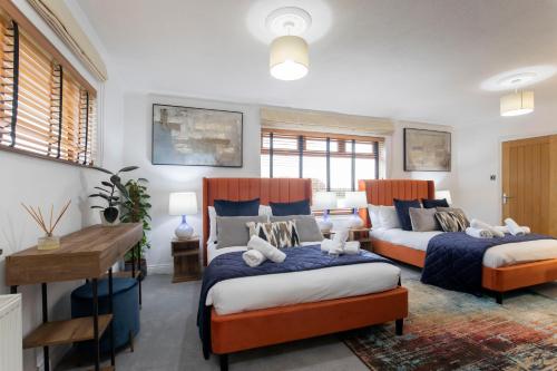 切爾滕納姆的住宿－Magnificent 3-Bedroom Home with Swim Spa，一间卧室配有两张床和一张书桌