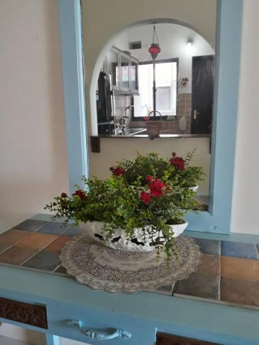 a vase with flowers on a table in front of a mirror at Premium Luxury -1BHK at Candolim Beach with Free Wifi and Pool in Candolim