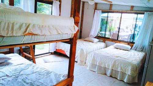 a room with two bunk beds and two windows at Paraíso Escondido in Tumbes