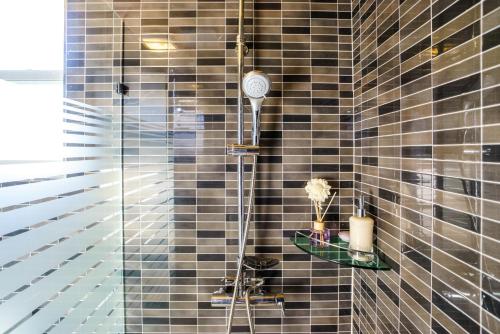 a shower with a shower head in a bathroom at Monteview Stay in Seogwipo