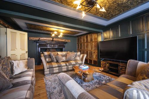 a living room with two couches and a television at Huge Deluxe 600 Year Old Essex Manor, Hot Tub, Cinema Room, Sky Tv in Saffron Walden