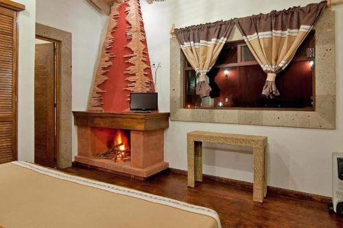 un salon avec une cheminée et une fenêtre dans l'établissement Mansion del Virrey, à Pátzcuaro