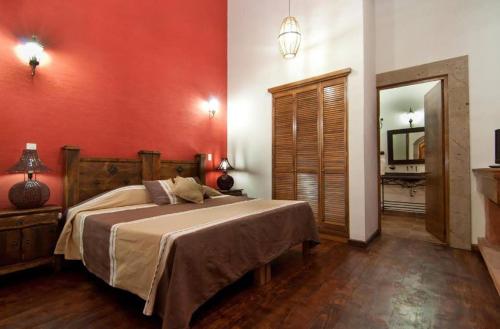 - une chambre avec un grand lit et un miroir dans l'établissement Mansion del Virrey, à Pátzcuaro