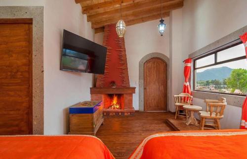 - une chambre avec une cheminée et une télévision dans l'établissement Mansion del Virrey, à Pátzcuaro