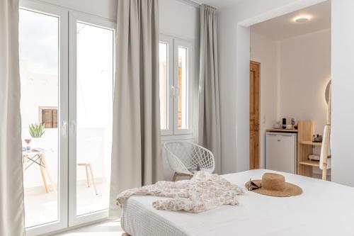 a white bedroom with a bed and a balcony at Golden Bird's in Naxos Chora