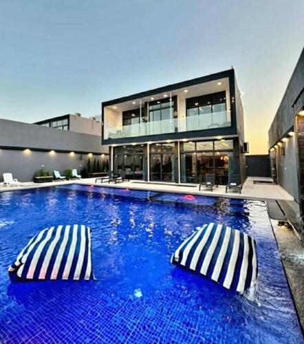 a swimming pool with two pillows in front of a building at Elysee Villa in Al Rama
