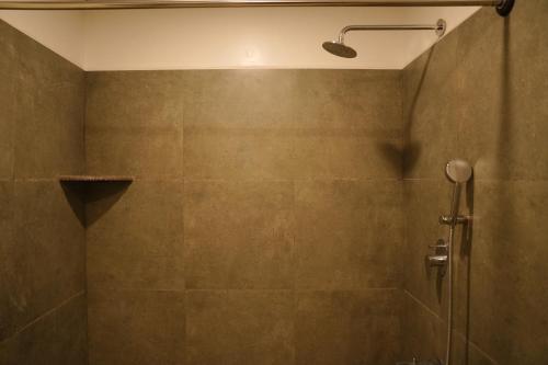 een douche met een glazen deur in de badkamer bij 12 degree comforts in Bangalore