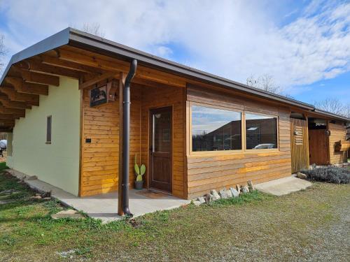 a small wooden cabin with a large window at Bosquey Ranch B&B in Alice Castello
