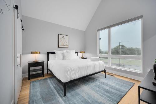 a bedroom with a bed and a large window at Noble Nash - 8 Mins to Grand Ole Opry in Nashville