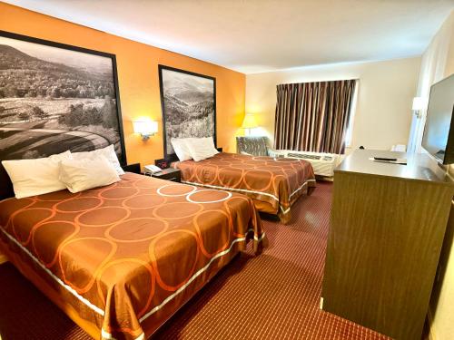 a hotel room with two beds and a television at Super 8 by Wyndham Hillsville in Hillsville