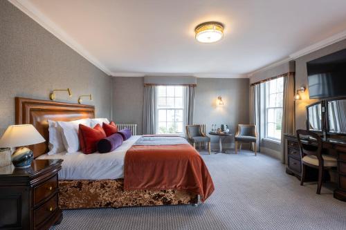 a bedroom with a large bed and a desk at Knipoch House Hotel in Oban
