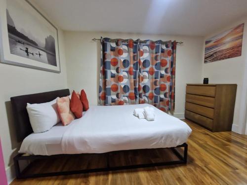 a bedroom with a large white bed and a curtain at Deluxe 1-Bed Apartment in Greenford in Greenford