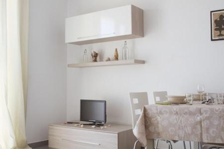 uma cozinha com uma mesa e uma televisão num armário em Center Boa Vista em Sal Rei