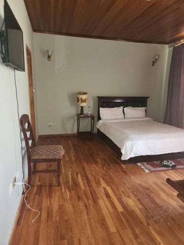 a bedroom with a bed and a tv and wooden floors at Luxury Gest house in Addis Ababa