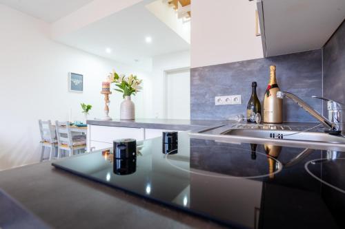 a kitchen with a sink and a counter with wine bottles at Ferienwohnung am Bug für 7 Gäste - Entspannung pur! #BugOase in Dranske