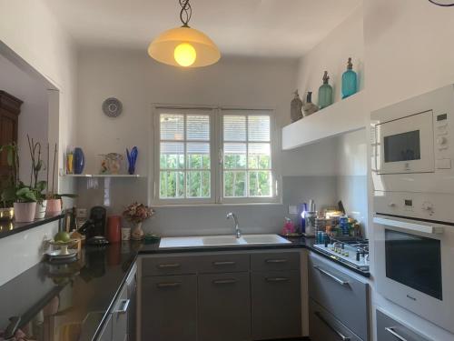 une cuisine avec un évier et une cuisinière four supérieur dans l'établissement Villa à 350m des calanques Saint Aygulf, à Saint-Aygulf