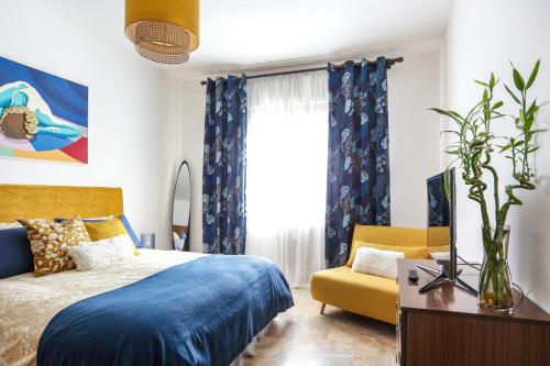 a bedroom with a blue bed and a yellow couch at Peggy's House in Venice
