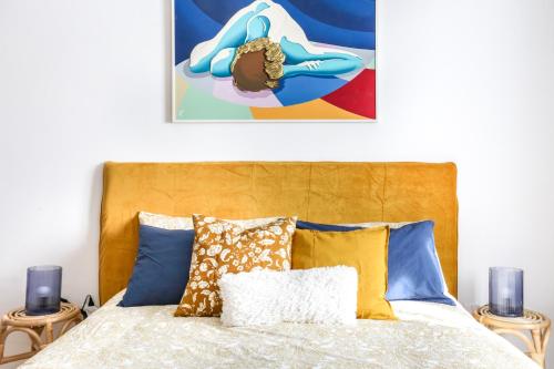 a bedroom with a bed with blue and yellow pillows at Peggy's House in Venice