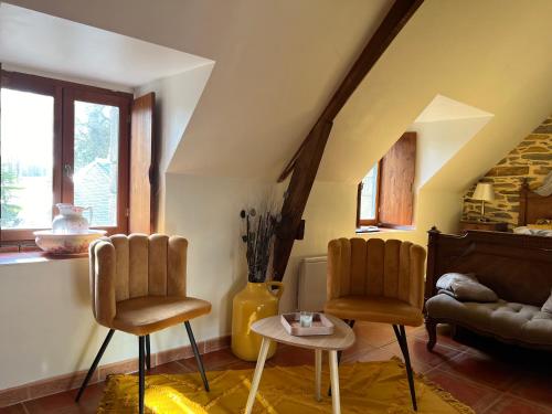 a living room with two chairs and a table at Le Clos Saint Fiacre in Carentoir