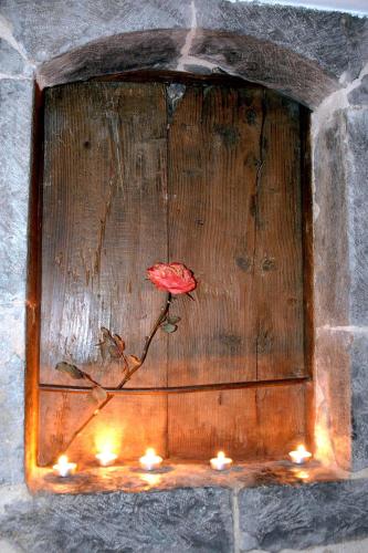 a red flower on a wooden plaque with candles at Archontiko Nikolopoulou in Vytina