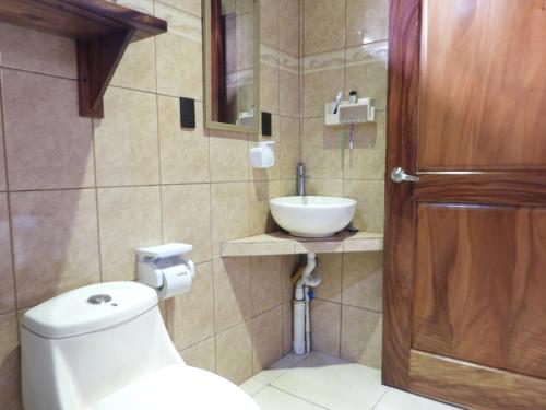 een badkamer met een toilet en een wastafel bij Casa las pavas Bijagüa in Bijagua