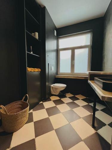baño con aseo y suelo a cuadros en Designer loft with sunny terrace, en Amberes