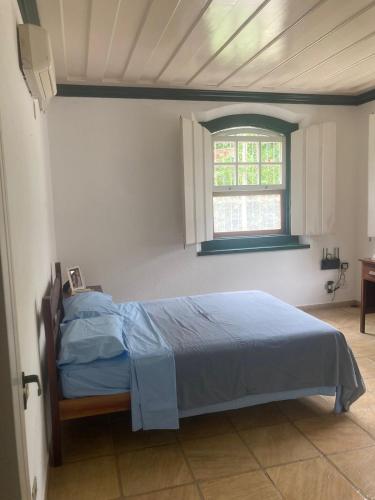 um quarto com uma cama num quarto com uma janela em CASA EM PARATY - EXCELENTE LOCALIZAÇÃO em Paraty