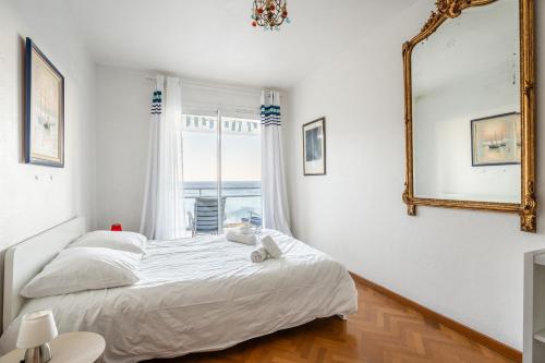 une chambre blanche avec un lit et un miroir dans l'établissement Le Super Bestouan par Dodo à Cassis, à Cassis