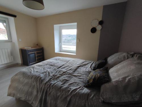 1 dormitorio con cama y ventana en Maison vigneronne climatisée en Polignac