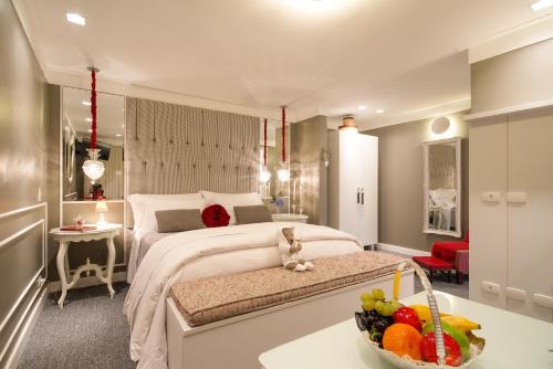 a bedroom with a bed and a bowl of fruit on a table at Casa Regaleira Hotel Boutique in Campos do Jordão