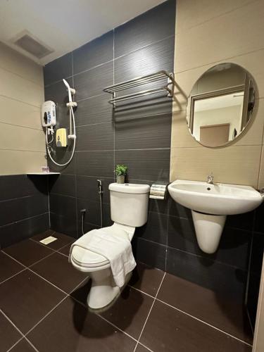 a bathroom with a toilet and a sink and a mirror at Swing & Pillows PJ Sunway Mentari formerly known as Swan Cottage Hotel in Petaling Jaya