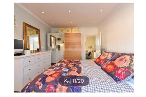 1 dormitorio con 1 cama, vestidor y TV en Veronika’s en Londres