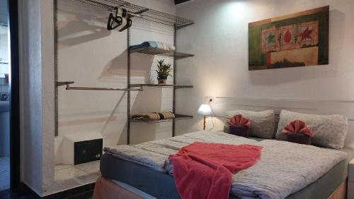 イコー・デ・ロス・ビノスにあるApartamentos-Monasterio-de-San-Antonio-Modernes-Apartment-mit-Balkon-und-Meerblickのベッドルーム1室(赤い毛布付きのベッド1台付)