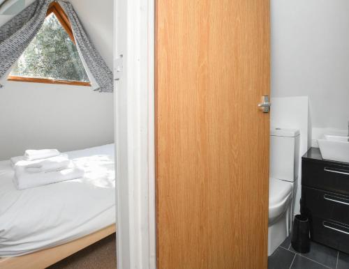 a door to a bedroom with a bed and a window at Chalet Thirtysix in Deal