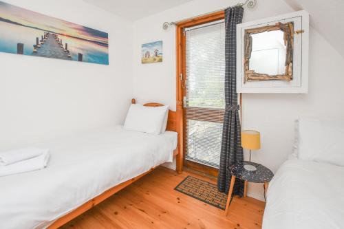 a bedroom with two beds and a window at Chalet Thirtysix in Deal