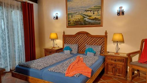 1 dormitorio con 1 cama, 2 lámparas y ventana en Apartamentos-Monasterio-de-San-Antonio-Rustikales-Apartment-mit-kleiner-Terrasse-im-Innenhof, en Icod de los Vinos