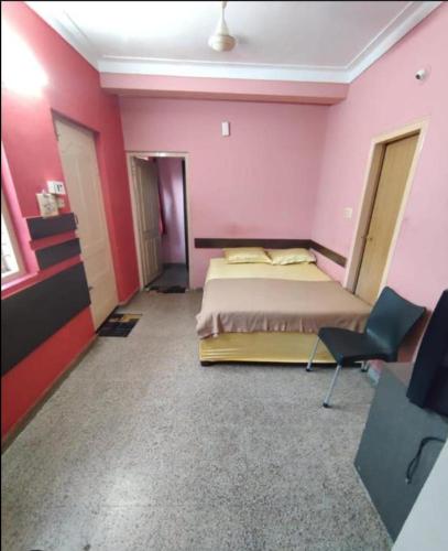 - une chambre avec un lit et un mur rose dans l'établissement Empire lodge, à Chikmagalur