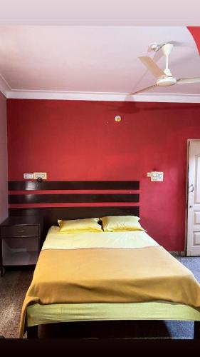 ein Schlafzimmer mit einer roten Wand und einem Bett in der Unterkunft Empire lodge in Chikmagalur