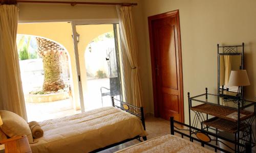 a bedroom with two beds and a sliding glass door at Villa Lobos in Lliber
