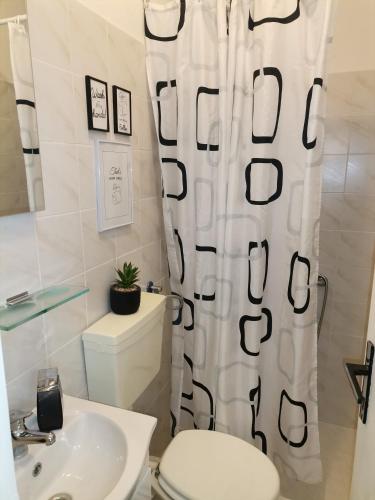 a bathroom with a toilet and a sink and a shower curtain at Studio Sofia in Novalja