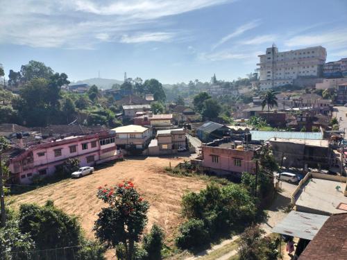 uitzicht op een dorp met gebouwen en auto's bij Coorg Orange Villa in Madikeri